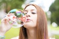 Closeup portrait of beautiful young woman inflating colorful soap bubbles.