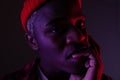 Closeup portrait of a black american man with big lips biting his finger in neon light Royalty Free Stock Photo