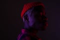 Closeup portrait of a black American man with big lips standing sideways in neon light Royalty Free Stock Photo