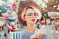Closeup portrait of blonde girl with short haircut in amusement park on baloons background. She wears checkered dress Royalty Free Stock Photo