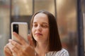 Closeup portrait of brown haired businesswoman using mobile phone looking at smartphone display with concentrated positive Royalty Free Stock Photo