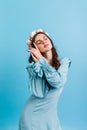 Closeup portrait of brunette in satin blue dress on isolated background. Lady sensually posing in crown of roses.