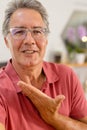 Closeup portrait of caucasian smiling senior man wearing glasses gesturing at home, copy space Royalty Free Stock Photo