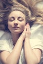 Closeup portrait of charming romantic soft girl beautiful young blond woman basking sun in bed Royalty Free Stock Photo