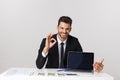 Closeup portrait of cheerful guy showing OK sign while resting on chair in office being satisfied isolated over gray Royalty Free Stock Photo