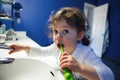 Closeup portrait of child toddler girl in bathroom toilet washing face hands brushing teeth with toothbrash Royalty Free Stock Photo