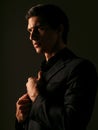 Closeup portrait of a confident man dressed in black suit portrait against a dark background