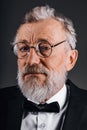 Closeup portrait of confident mature man in tuxedo isolated on black background