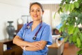 Smiling young female health worker standing in medical office Royalty Free Stock Photo