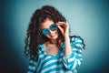 Curly woman with sunglasses posing and smiling