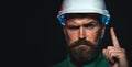 Closeup portrait of construction worker in hard hat pointing finger up. Bearded man protective helmet. Building Royalty Free Stock Photo