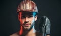 Closeup portrait of construction worker in safety hard hat with spade. Serious bearded man in construction helmet with Royalty Free Stock Photo