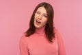 Closeup portrait of coquettish funny brunette woman in pink sweater winking looking at camera, cheering up with wink
