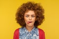 Closeup portrait of crazy woman with fluffy curly hair demonstrating tongue out and making silly face with crossed eyes