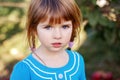 Closeup portrait of cute adorable little red-haired Caucasian girl child with blue eyes