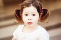 Closeup portrait of cute adorable sad upset white Caucasian toddler girl child with dark brown eyes and curly pig-tails Royalty Free Stock Photo