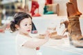 Closeup portrait of cute adorable sad upset white Caucasian toddler girl child with dark brown eyes and curly pig-tails