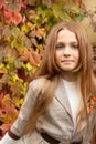 Closeup portrait of cute adorable serious teen red-haired Caucasian girl child in autumn fall park outside, looking in camera, Royalty Free Stock Photo