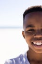 Closeup portrait of cute african american boy smiling against sea and clear sky on sunny day Royalty Free Stock Photo