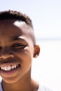 Closeup portrait of cute african american boy smiling at beach against clear sky on sunny day Royalty Free Stock Photo