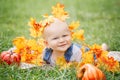 Closeup portrait of cute funny adorable blond Caucasian baby boy with blue eyes in tshirt and jeans romper lying on grass field Royalty Free Stock Photo