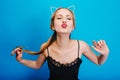 Closeup portrait of cute girl giving kiss to camera, posing on blue background, enjoying party, masquerade, carnival