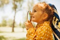 Closeup portrait of cute happy little girl playing and exploring with magnifying glass the nature outdoor. Curious child looking Royalty Free Stock Photo