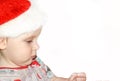 Closeup portrait of a cute little baby boy wearing red Santa Claus hat isolated on white background, traditional Christmas costume Royalty Free Stock Photo