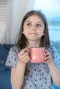 Closeup portrait of a cute little girl with a white milk mustache looking at the camera, pleased charming child with a Royalty Free Stock Photo