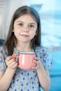 Closeup portrait of a cute little girl with a white milk mustache looking at the camera, pleased charming child with a Royalty Free Stock Photo