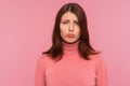 Closeup portrait of deeply upset frustrated brunette woman in pink sweater looking at camera, disappointment