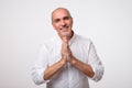 Closeup portrait of desperate mature man in white shirt showing clasped hands,asking for help or excuse. Royalty Free Stock Photo