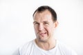 Closeup portrait of disgusted 30 years old caucasian white man on white background in white t-shirt. Man making weird face and
