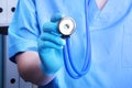 Closeup portrait of a doctor with a stethoscope on a background of a shelf with folders.