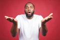 Closeup portrait of dumb clueless young african man, arms out asking why what`s the problem who cares so what, I don`t know. Royalty Free Stock Photo