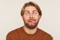 Closeup portrait of dumb fool bearded man looking cross-eyed and showing tongue out, fooling around Royalty Free Stock Photo