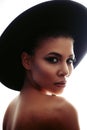 Closeup portrait of an extraordinary beautiful stylish metis young woman with perfect smooth glowing mulatto skin in a hat