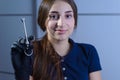 Closeup portrait of a female dentist doctor holding a refillable metal syringe for anesthesia in her hand. At the dental