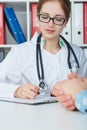 Closeup portrait of female doctor taking notes in medical history. Ward round, patient visit check, medical calculation Royalty Free Stock Photo