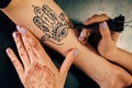 Artist applying henna mehndi tattoo on female hand Royalty Free Stock Photo