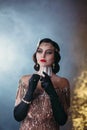 Closeup portrait flapper woman with glass of red wine. golden headband, finger wave hairstyle, vintage style 20s dress