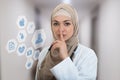 Closeup portrait of friendly, confident muslim with hijab doctor showing shh sigh, silence.