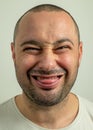 Closeup portrait of funny angry young bully man sticking his tongue out at you camera gesture, isolated on white Royalty Free Stock Photo