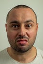 Closeup portrait of funny angry young bully man sticking his tongue out at you camera gesture, isolated on white Royalty Free Stock Photo