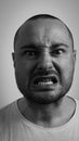 Closeup portrait of funny angry young bully man sticking his tongue out at you camera gesture, isolated on white Royalty Free Stock Photo