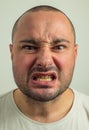 Closeup portrait of funny angry young bully man sticking his tongue out at you camera gesture, isolated on white Royalty Free Stock Photo