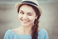 Closeup portrait of funny beautiful smiling white Caucasian brunette girl winking, in blue dress and straw hat