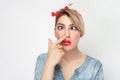 Closeup portrait of funny crazy crossed eyes young woman in casual blue denim shirt with makeup and red headband standing looking Royalty Free Stock Photo