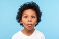 Closeup portrait of funny goofy little boy with curly hair making fish face with pout lips and big eyes Royalty Free Stock Photo