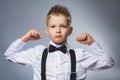 Closeup Portrait of Funny Little child. Sport Handsome Boy. Strong serious kid showing his hand biceps muscles Royalty Free Stock Photo